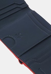 Navy leather wallet with red accents, featuring card slots, RFID protection, and textured exterior. Neat stitching details.