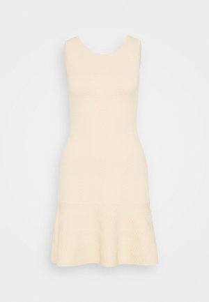 Vestido crema sin mangas hasta la rodilla con dobladillo acampanado y un sutil patrón texturizado sobre un fondo blanco liso.