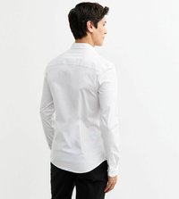 Witte lange mouwshirt met een klassieke kraag, rugdeel naad en afgeronde zoom, gecombineerd met donkere broeken, die een gladde textuur tonen.