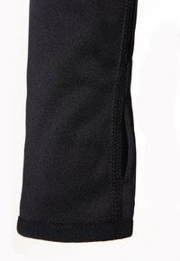 Manica atletica nera con una texture liscia, dotata di una zip laterale e orlo cucito. Il design presenta una finitura leggermente lucida.