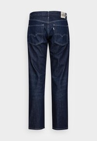 Jeans de mezclilla azul oscuro con un diseño de pierna recta, que cuentan con dos bolsillos traseros con costuras contrastantes y una etiqueta de marca visible en la cinturilla.