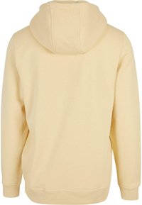 Felpa gialla con cappuccio, dalla texture liscia, con tasca a marsupio e polsini a costine. Design semplice e sobrio, senza motivi né dettagli.