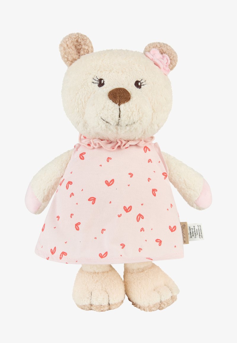 Ours en peluche avec une fourrure beige, portant une robe rose ornée de motifs de cœurs rouges, une fleur rose sur l'oreille, et un visage brodé, debout.