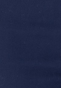 Marineblauwe katoenen stof met een gladde textuur, met lichte pluisjes en een uniforme kleur zonder patronen of versieringen.