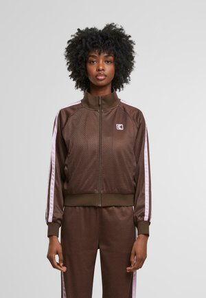 Brown perforated track jacket with a high collar, zip, and pink side stripes. Features ribbed cuffs and a logo on the chest.