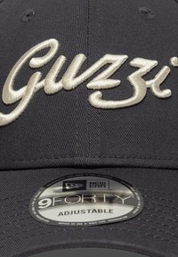 Μαύρο ρυθμιζόμενο καπέλο με κεντημένο το λογότυπο "Guzzi" σε εκρού χρώμα. Ετικέτα 9FORTY ορατή στην κάτω πλευρά με λεπτομέρειες υφής υφάσματος.