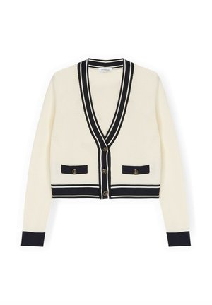 Roomkleurig vest met zwarte biezen en manchetten, V-hals, knoopsluiting en twee voorzakken met knopen.