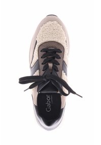 Sneaker met een beige en zwart ontwerp, voorzien van een textuurpaneel van crème stof, zwarte veters en een gevoerde binnenzool met branding.