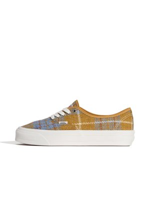 Canvas sneakers in yellow plaid with blue accents, white rubber outsole, and contrasting white laces. Features a branded label on the side.