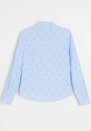 Jasnoniebieska koszula z długim rękawem z małymi ciemnymi motywami kwiatowymi, mankietami na guziki i klasycznym kołnierzem, widziana od tyłu na białym tle.