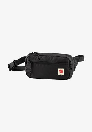 Mala de cintura em nylon preto com um bolso frontal com fecho, alça ajustável e um pequeno patch com um emblema vermelho. Textura suave e design compacto.