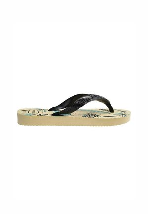 Chancla beige con tiras negras y estampado tropical en la suela, mostrada de lado sobre un fondo blanco.