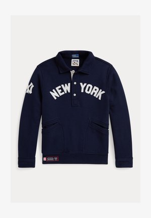 Temno modra pulover majica z ovratnikom polo, belo besedilo "NEW YORK", dvema sprednjima žepoma in dekorativno zakovico na dnu.