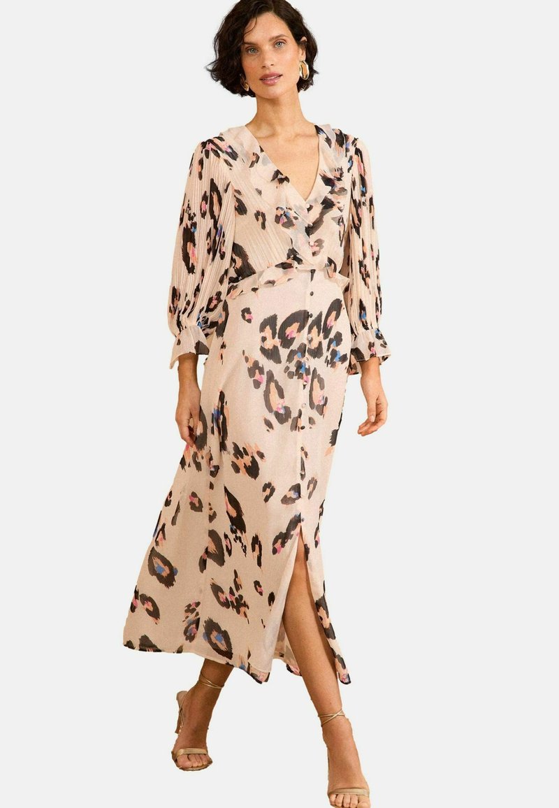 Leopardi mustriga midi kleit kerge kangaga, millel on sügav V-kaelus, pikad volditud varrukad ja ees olev lõhik. Värvipalett sisaldab beeži, musta ja roosat.