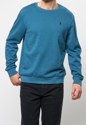 Blaues Baumwoll-Sweatshirt mit rundem Ausschnitt, langen Ärmeln und einem gerippten Saum. Verfügt über ein kleines gesticktes Logo auf der Brust.