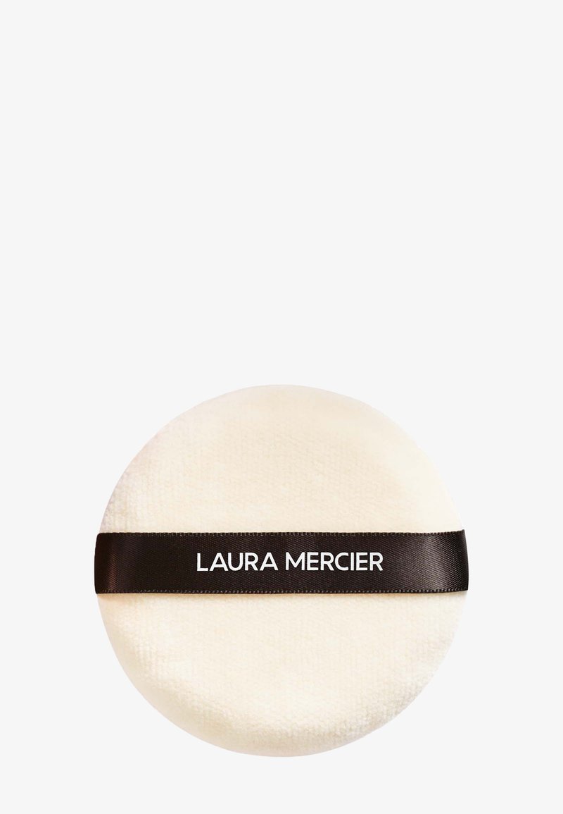 Cuscino in polvere rotondo e morbido di colore crema con una consistenza soffice. Presenta un nastro marrone scuro etichettato "LAURA MERCIER" per una presa e un uso più agevoli.