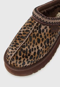 Leopardprint instapper met gestikt randje, bruine zool en zachte binnenvoering, met een klein UGG-logo-label.