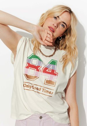 T-shirt en coton crème avec un grand design multicolore "84" orné de pois et d'accents scintillants, accompagné du texte "Only Good Times".