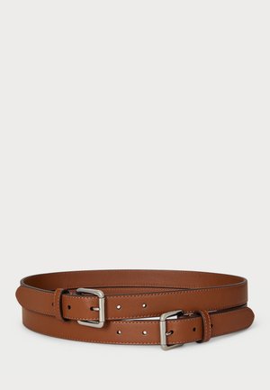 Deux ceintures en cuir marron avec des boucles métalliques argentées placées enroulées sur un fond clair.
