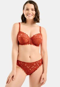 Lace bra and panty set in deep red. Bra with underwire, scalloped edges, and adjustable straps. Panty features lace with a similar scalloped design.