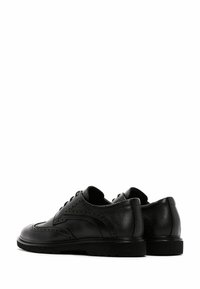 Chaussures en cuir noir avec un design perforé, bout arrondi et semelle en caoutchouc basse. Présentent une texture lisse et un système de laçage simple.
