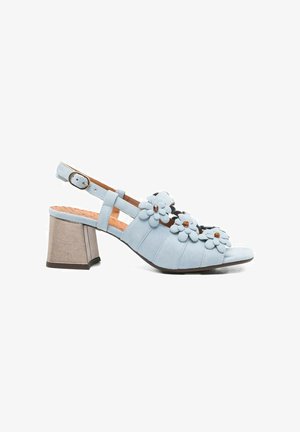 Sandalo slingback azzurro chiaro con tacco a blocco e applicazioni floreali decorative sulle cinghie, chiusura con fibbia regolabile.