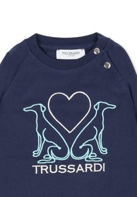 T-shirt en coton bleu marine avec deux chiens brodés en bleu clair et un cœur entre eux. Comprend des boutons-pression à l'épaule.