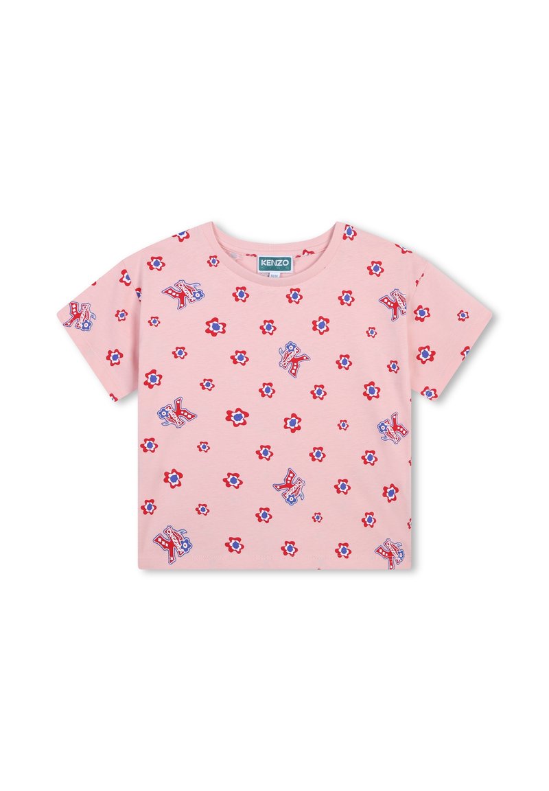 T-shirt en coton rose avec des motifs floraux et de lettres dispersés en rouge et bleu, avec un col rond et des manches courtes.