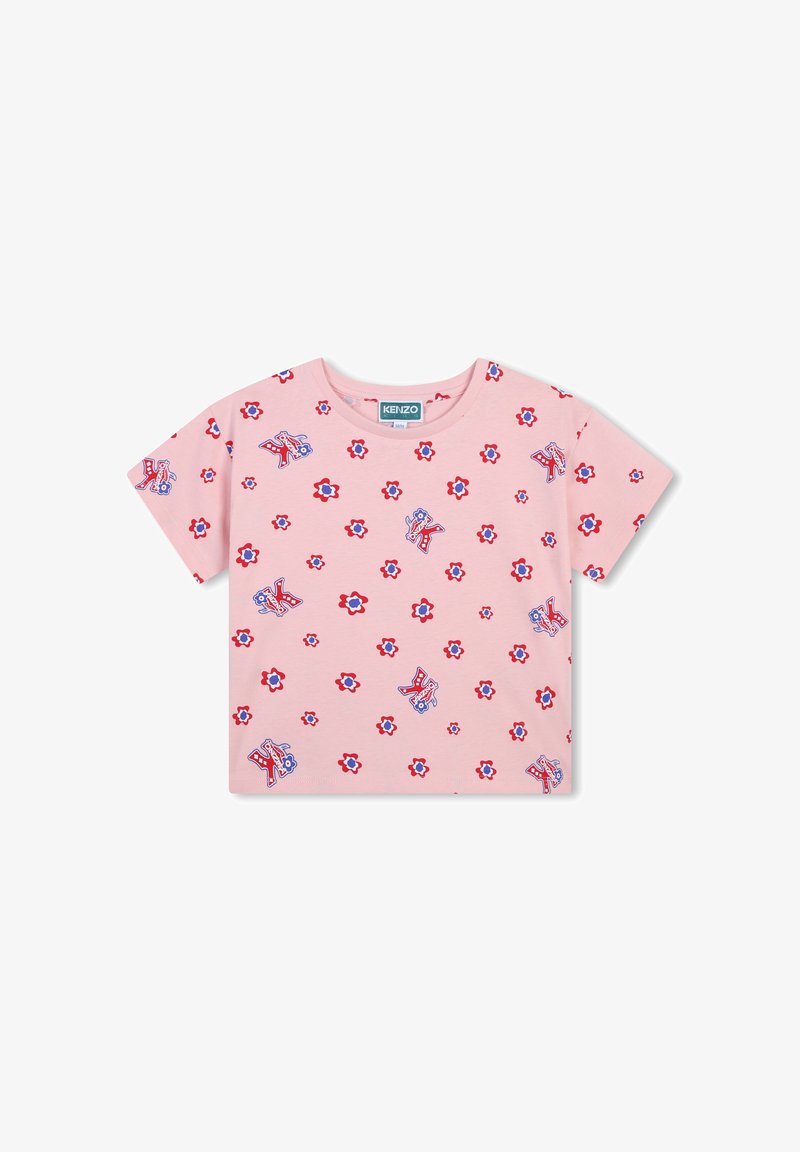 T-shirt en coton rose avec des motifs floraux et de lettres dispersés en rouge et bleu, avec un col rond et des manches courtes.
