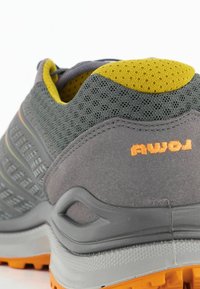 Graues Outdoor-Schuhwerk mit einem atmungsaktiven Mesh-Obermaterial, gelben Akzenten am Kragen und einem orangefarbenen Logo. Gummisohle mit strukturiertem Grip.