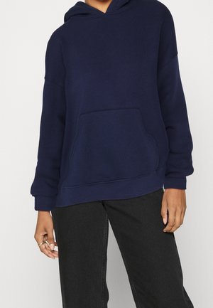 Marineblå hættetrøje lavet af blødt stof, med en kengurulomme, afslappet pasform og ribbede manchetter og kant.