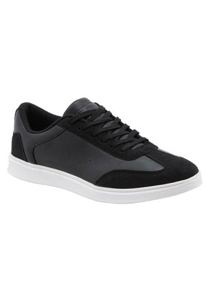 Zwarte lage sneaker met zwarte veters, gladde en suède panelen, en een witte rubberen zool, getoond in een rechte zij-aanzicht.