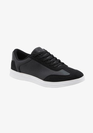 Baskets basses noires avec lacets noirs, panneaux lisses et en suède, et semelle en caoutchouc blanche, vues de profil à angle droit.