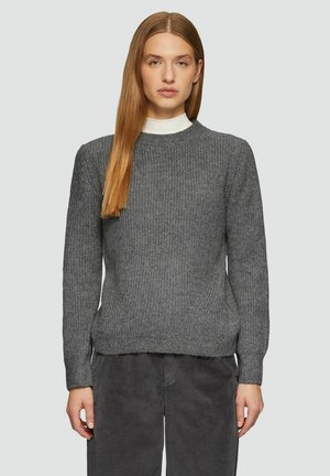 Gray knitted sweater with a round neckline and long sleeves. Features ribbed texture and a relaxed fit. Paired with dark corduroy pants.