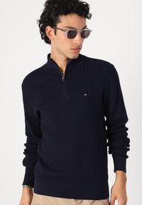 Navy Zip-Jumpers aus strukturiertem Strickstoff mit Fischgrätmuster sowie Rippbündchen und -saum; verfügt über ein kleines Logo-Patch.