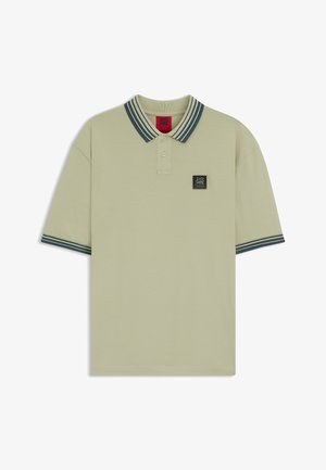 Jasnozielona koszulka polo z dwukolorowym kołnierzykiem z ciemnymi paskami, krótkimi rękawami i czarną naszywką z logo na piersi.
