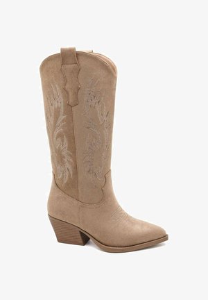 Bottes de cowboy beiges en daim avec bouts pointus, coutures décoratives, une languette de tirage et un talon empilé.