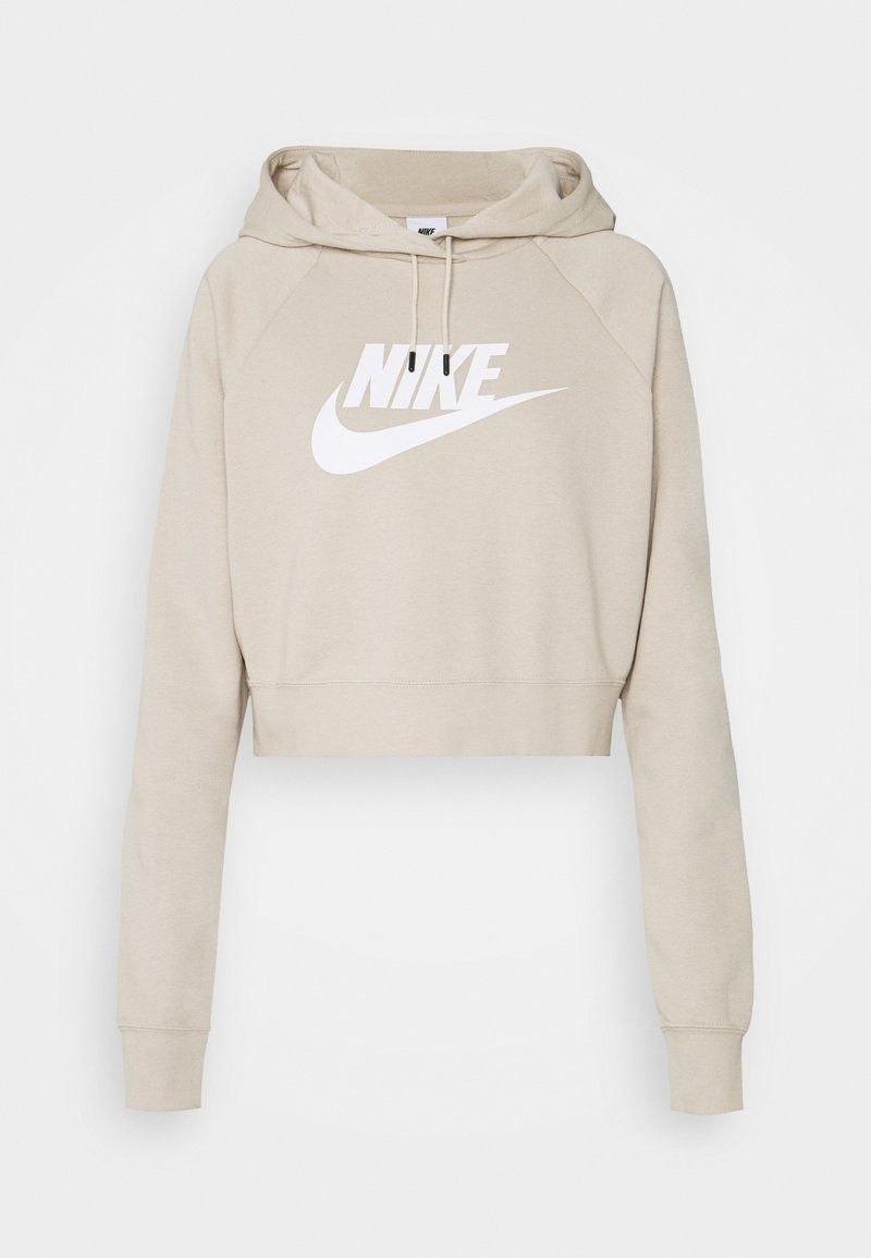 Sudadera corta beige hecha de tela suave, con un gran logo blanco de Nike en la parte frontal, con cordones y mangas largas.