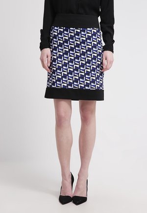Jupe longueur genou avec un motif géométrique bleu, blanc et noir et une taille noire unie, fabriquée en tissu texturé.