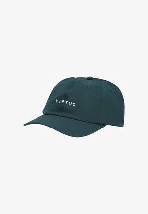 Jeune homme à la peau claire et aux yeux bleus portant une casquette de baseball vert foncé avec le texte "VIRTUS" et un t-shirt noir à col rond.