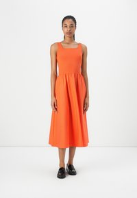 Orange, sleeveless dress made from ribbed fabric. Features a square neckline and a gathered waist, falling to mid-calf length.