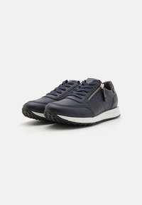 Dunkelblaue Leder-Sneaker mit Schnürung und seitlichem Reißverschluss. Mit weißem Zwischensohlen und schwarzem strukturiertem Gummiausstoß.