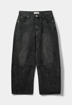 Pantalons en denim gris foncé à jambes larges, avec une texture légèrement déchirée, dotés de poches avant et d'une fermeture à bouton à la taille.
