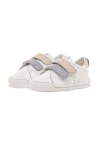 Zapatillas blancas con lados de malla, que presentan correas de Velcro en beige y gris. Parte superior texturizada con pequeñas perforaciones y suela de goma.