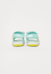 Blaue Sandalen mit verstellbaren Riemen und gelben Sohlen. Texturiertes weißes Fußbett, das kleine Blumenakzente an den Riemen aufweist. Rückansicht.