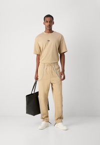 HUGO NIPIPEPANT - Pantalones deportivos - medium beige