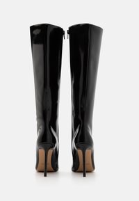 Stivali neri in pelle verniciata al ginocchio con un design elegante, punta affusolata e tacco a stiletto sottile; dotati di una zip sul retro.