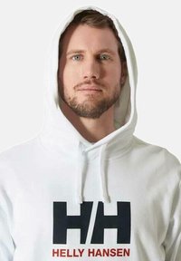 Sudadera blanca con cordones, que presenta un gran logo negro "HH" y el texto rojo "HELLY HANSEN" en la parte delantera. Tejido suave, corte relajado.