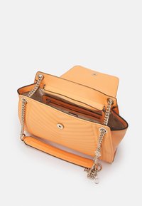 Torebka skórzana w kolorze pomarańczowym z pikowaniem, z łańcuszkowym uchwytem, przednią klapą, zapięciem magnetycznym oraz kieszeniami wewnętrznymi. Posiada czarne wykończenia i podszewkę.