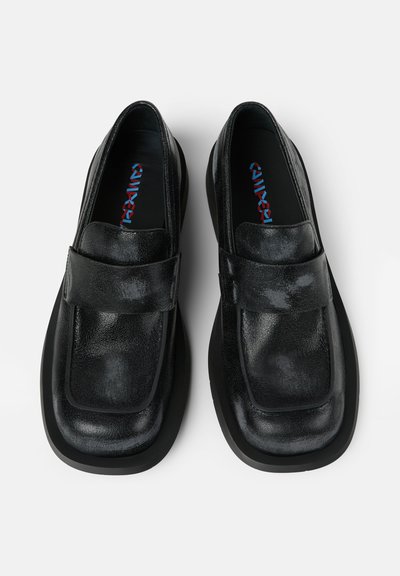 Svarta läderslippers med en strukturerad yta, fyrkantig tå, bred rem över fotryggen och en tjock svart sula.